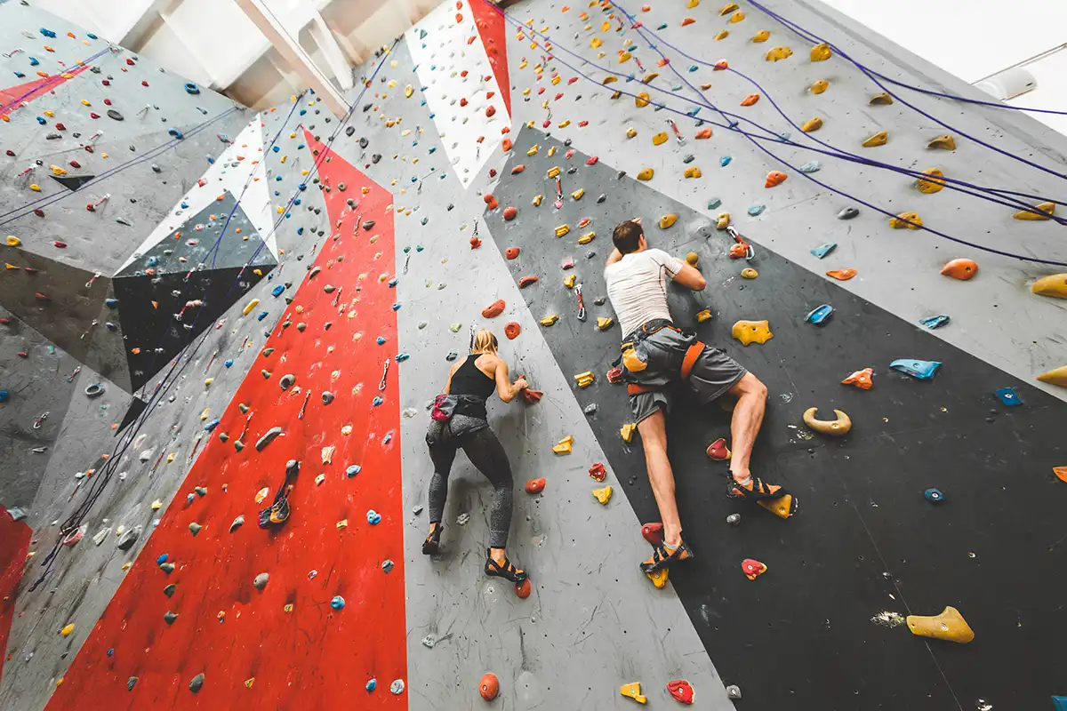  couple of athletes climber moving up on rock