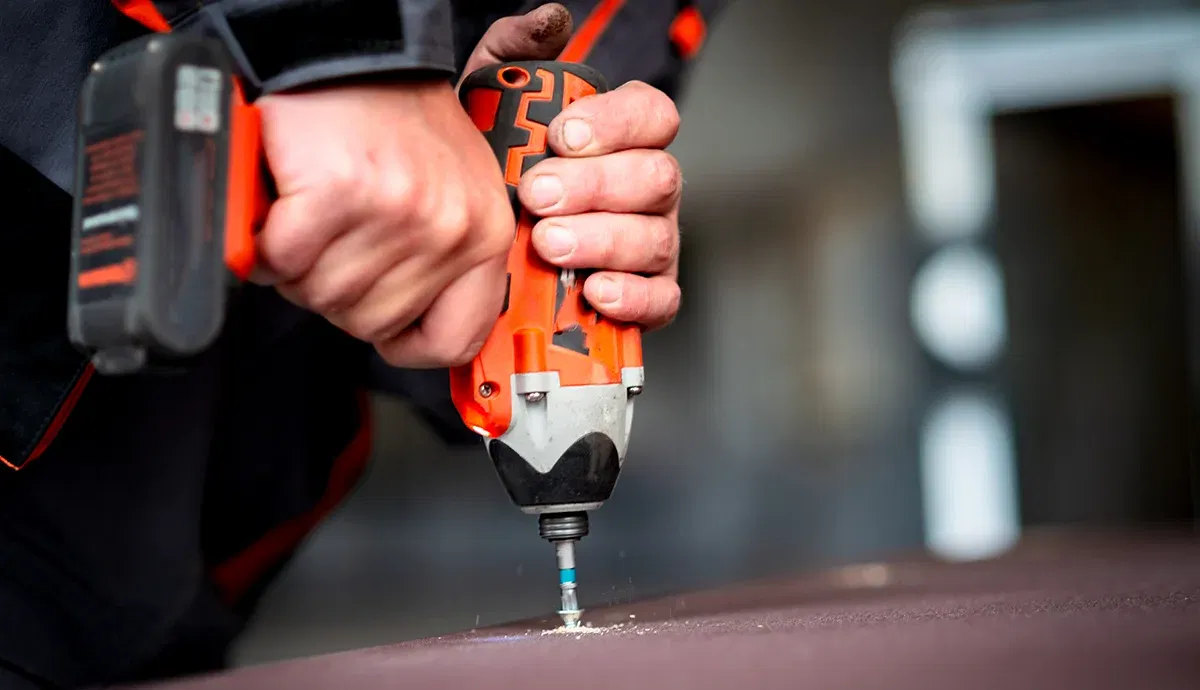 Worker using a cordless drill for drilling