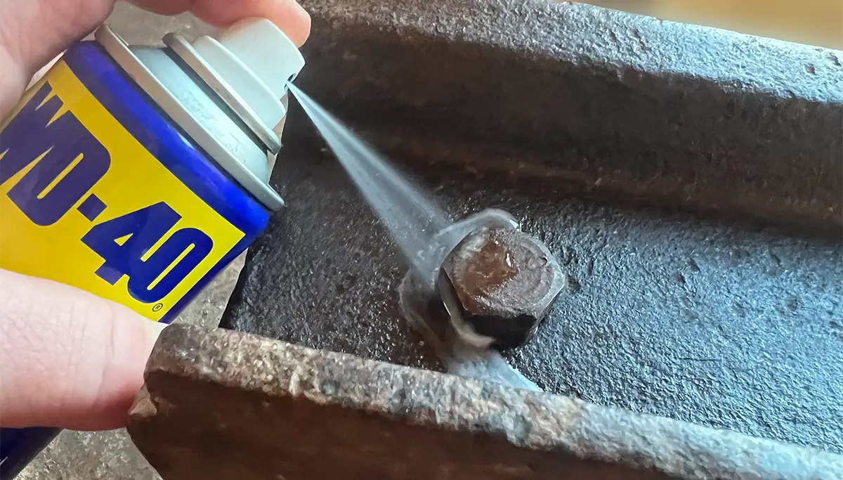 Rostige Schraube wird mit WD-40 besprüht Rostige Schraube wird mit WD-40 besprüht