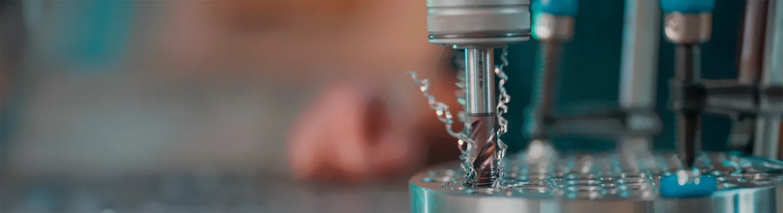 Ein Gewinde wird mit einem Maschinengewindebohrer in einen Metallblock geschnitten
